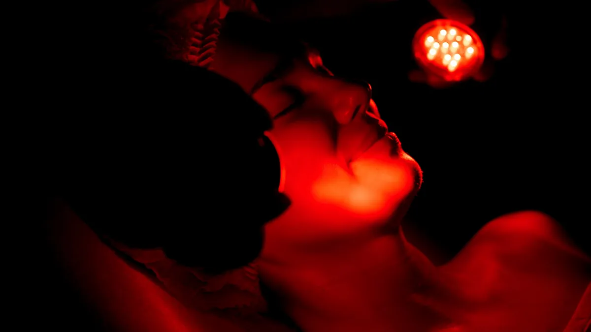 a beautiful woman getting red light therapy on the face